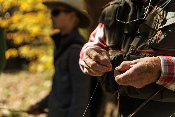 Close up of a man tying a lure on his fishing line