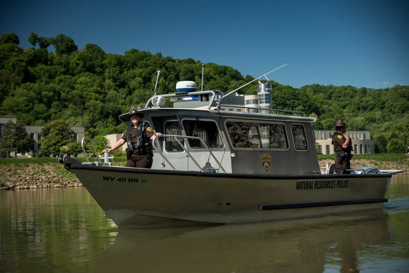 Natural resources police officers on patrol boat on a river